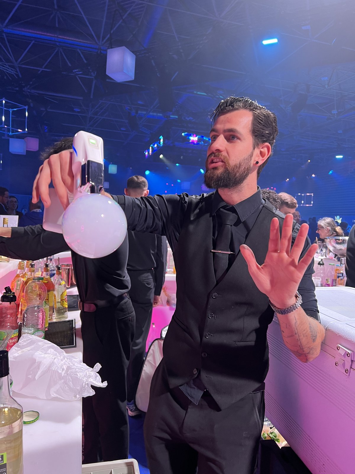 Barman présentant une bulle aromatique au-dessus d'un cocktail