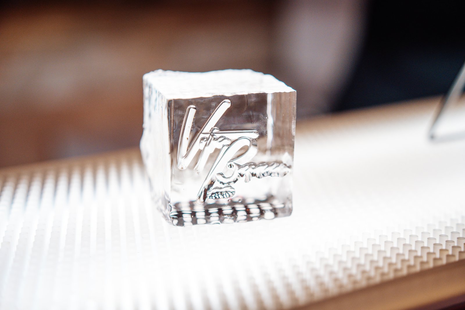 Glaçon de glace claire gravé VB dans un cocktail, savoir-faire premium